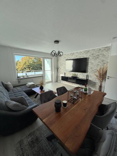 a living room with a wooden table and a couch at 3-room apartment - near airport & Hamburg in Norderstedt