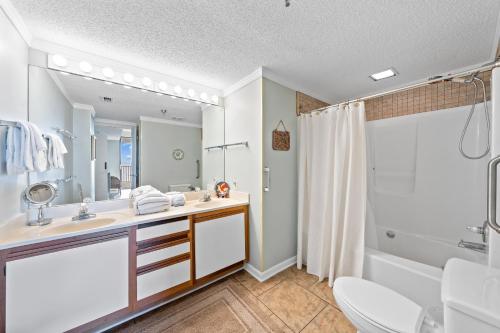 une salle de bain avec un lavabo, une baignoire et un miroir dans l'établissement Romar Place 705 by Vacation Homes Collection, à Romar Beach