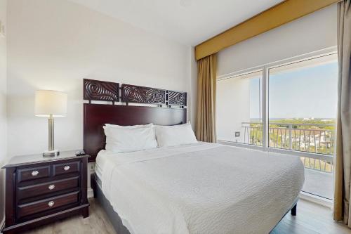 Un dormitorio con una cama y una ventana grande. en Luau 6909, en Destin