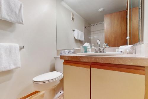 a white bathroom with a toilet and a sink at Simba Run 2305 in Vail
