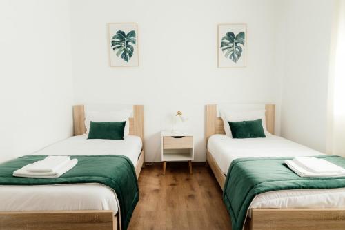 two beds in a room with green and white at Quinta das Laranjeiras in Marinhais