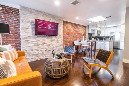 a living room with a couch and chairs and a brick wall at Family-Friendly Apartment with Kitchen in San Diego