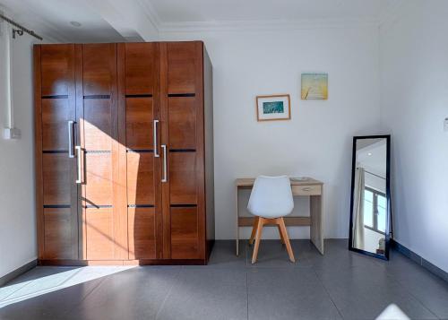 a wooden door in a room with a desk and a chair at Villa Paradis à 100m de la plage in Flic-en-Flac