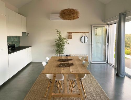 a kitchen and dining room with a wooden table and chairs at Vistâme in Almoster