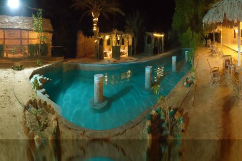 a large swimming pool at night with at agyptus camp in Siwa