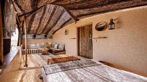 a bedroom with a bed and a couch at Berber Beldi Camp in Imsouane