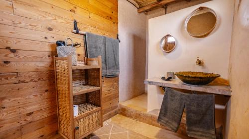 a bathroom with a sink and a wooden wall at Berber Beldi Camp in Imsouane