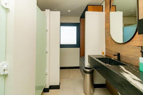 a bathroom with a sink and a mirror at Ap com piscina, ótima localização in Canela