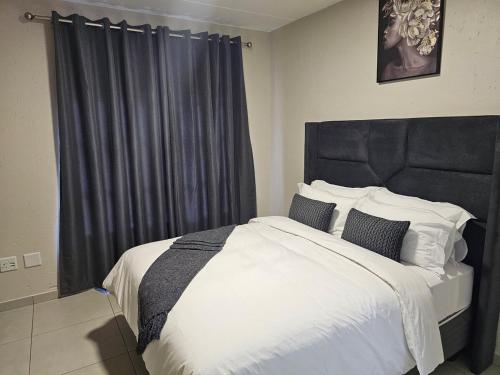 a bedroom with a large bed with a black headboard at Eland Ridge in Boksburg