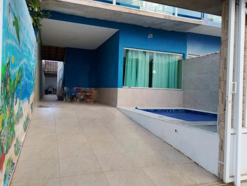 a room with a blue wall and a swimming pool at Casa Balneário Arpoador in Peruíbe