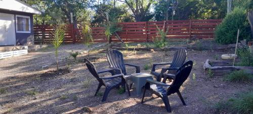 three chairs and a table in a yard at cabañas Saona in Molinari
