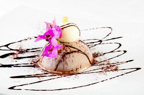 a chocolate egg with a purple flower on a plate at Hotel Onda Verde in Praiano
