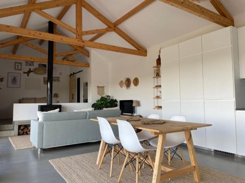 a kitchen and living room with a wooden table and chairs at Vistâme in Almoster