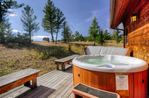 a hot tub on a deck next to a bench at Antler Ridge Lodge in Big Sky