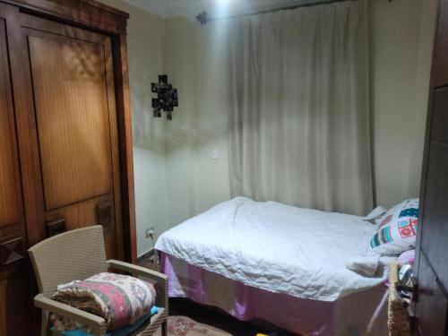 a small bedroom with a bed and a window at Villa hossam elkady in Maḩaţţat Wardān