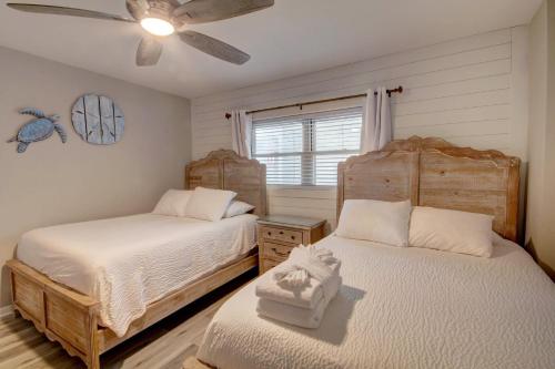 a bedroom with two beds and a ceiling fan at El Matador 430 - Third floor unit in Fort Walton Beach