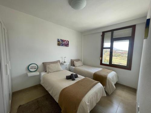 a bedroom with two beds and a window at Vistas al mar, montaña y volcán in El Paso