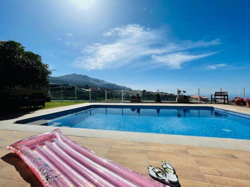 a swimming pool with a bench in front of it at Vistas al mar, montaña y volcán in El Paso
