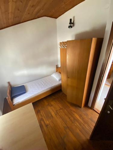 a small room with a bed and a wooden cabinet at Apartman Dinja in Posušje