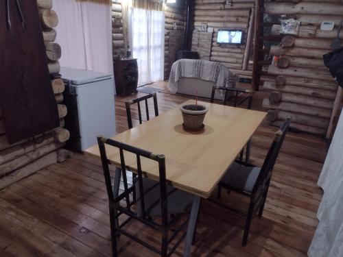 a dining room with a wooden table and chairs at La cabaña in Sánchez