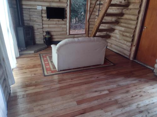 a couch sitting on a wood floor in a room at La cabaña in Sánchez