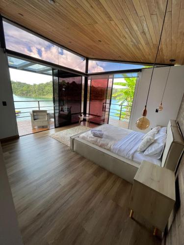 een slaapkamer met een bed en een groot raam bij Boreal Glamping in Guatapé