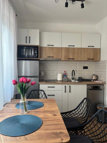 a kitchen with a wooden table and some chairs at Apartman Harmonija in Bajina Bašta