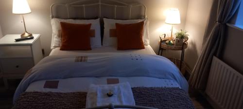 a bedroom with a large white bed with orange pillows at Elder Grove House in Castleisland
