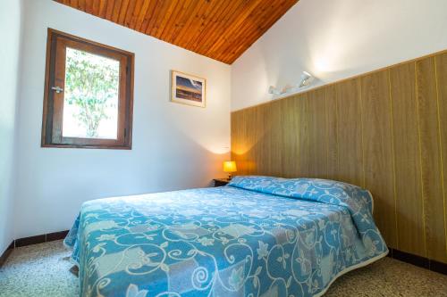 a bedroom with a bed and a window in it at Résidence les Arbousiers in Saint-Florent