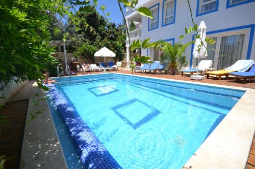 a swimming pool in a house with a blue wall at Kelebek Apartments in Kalkan