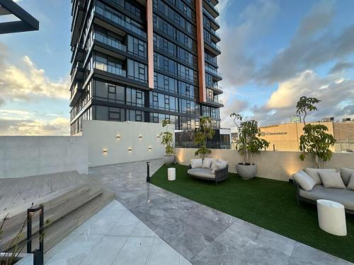 an apartment patio with couches and a building at Cosmopolitan TJ - Costco and San Ysidro Border USA in Tijuana