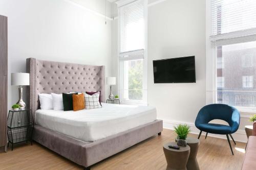 Un dormitorio con una cama grande y una silla azul. en Bright 2BR Loft Sleeps 7 with Full Kitchen and Fast WiFi, en San Diego