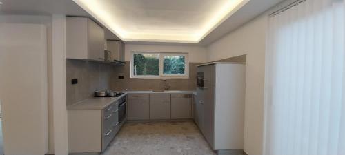 a large kitchen with a sink and a window at Holiday Home Villa Zonnebeke in Zonnebeke