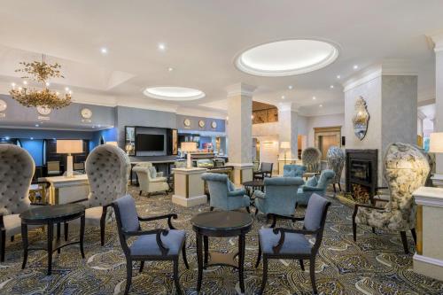 a lobby with chairs and tables and a living room at Protea Hotel by Marriott Johannesburg Balalaika Sandton in Johannesburg
