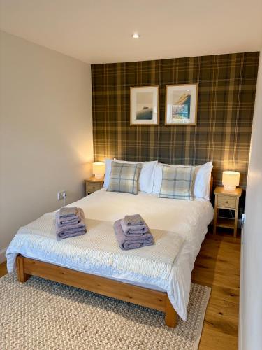 a bedroom with a bed with two towels on it at Tiny House in Cosy Village in Milnathort