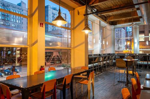 a restaurant with tables and chairs and large windows at HI Chicago Hostel in Chicago