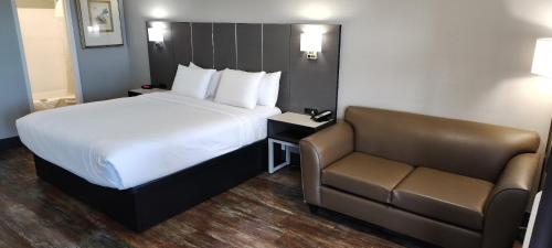 a hotel room with a bed and a couch at Anderson Inn in Anderson