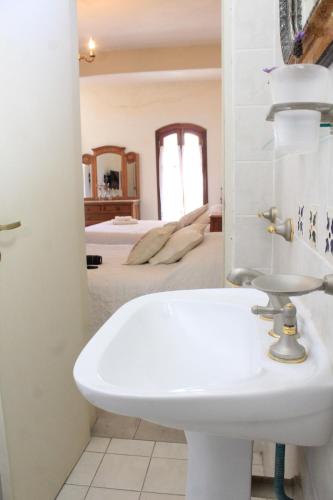 a bathroom with a sink and a bedroom at Alta Gracia Hotel Boutique in Alta Gracia