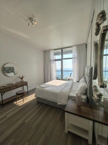 a bedroom with a bed and a desk and a window at برج داماك جده شقه مطله على البحر damac jeddah in Jeddah