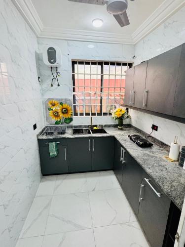 a kitchen with green cabinets and flowers in it at The Best In Accra Modern 1 Bedroom Stylish & Private Oyarifa Escape with Breathtaking Mountain Views Fast WiFi Onsite Security Minutes from Top Restaurants Shops And Essentials Airport Pickup City Tours Book Now in Oyarifa