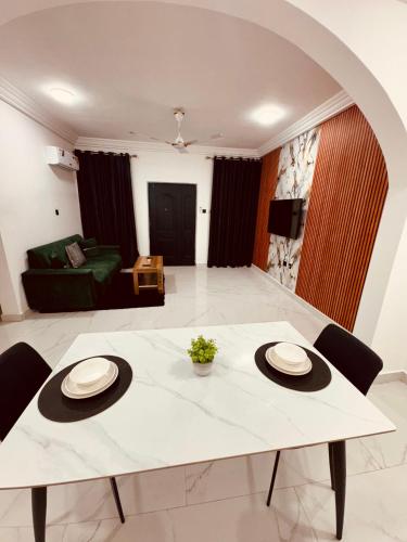 a living room with a white table and chairs at Modern 1 Bedroom Ground Floor Apartment with Serene Mountain Views, close to Aburi Walking Trail in Oyarifa