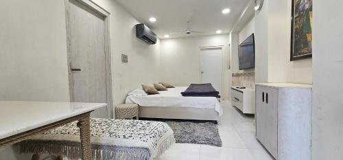 ein Schlafzimmer mit zwei Betten, einem Tisch und einem Fernseher in der Unterkunft Shanti Niwas Jodhpur, Rajasthan in Jodhpur