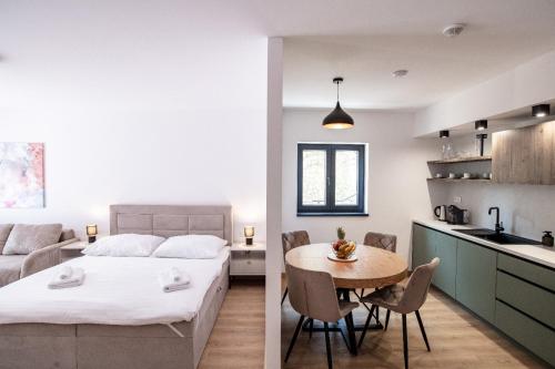 a bedroom and a kitchen with a bed and a table at Villa Cherry in Rogoznica