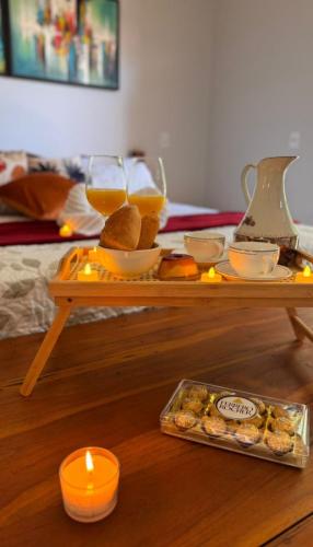 a tray with food and drinks on a table with candles at Casa Das Árvores BonitoMS in Bonito