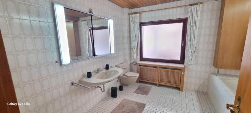 Casaba Suite -260 qm-2 floors- 7 Rooms-Free Private Parking-House with garden في هانوفر: حمام مع حوض ومرحاض ونافذة