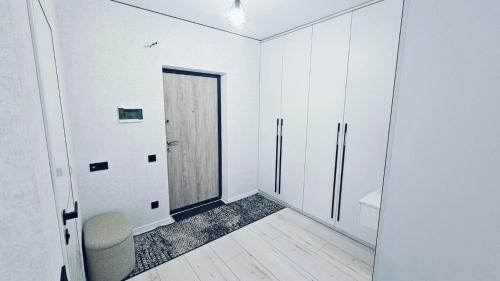 a white room with a door and a chair at ЖК ДрімТаун Люкс апартаменти Євродвійка in Lutsk