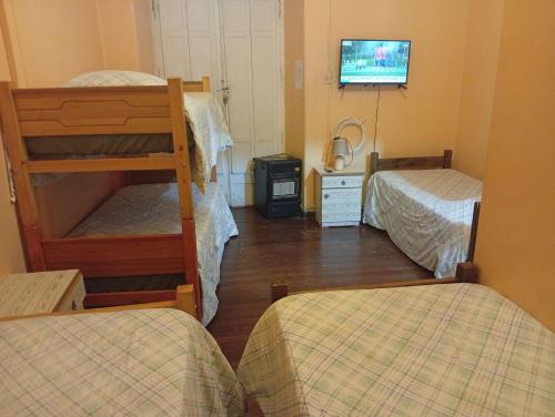 a room with two bunk beds and a flat screen tv at Hostería Residencial Santa Rosa in Los Andes