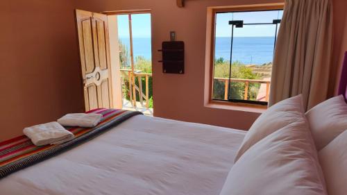 a bedroom with a bed with a view of the ocean at Titicaca Lodge Amantani in Ocosuyo