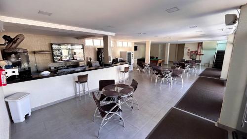 Un restaurante con barra, mesas y sillas. en Pietro Angelo Hotel, en Foz do Iguaçu