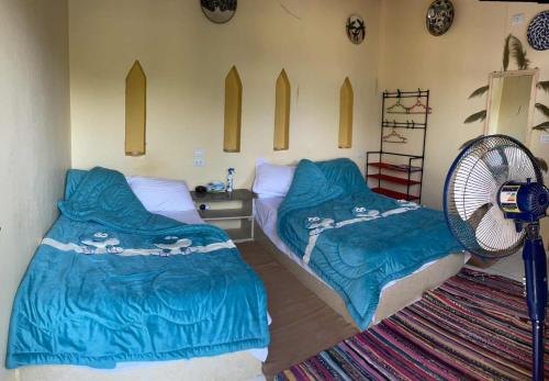 Un dormitorio con dos camas y un ventilador. en Tunis Camp, en Tunis